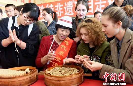 图为大学生学习传统面食莜面的制作方法。　曹艺 摄